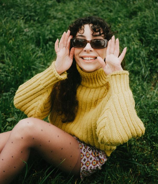 Woman feeling happy and energetic in a bright natural environment.